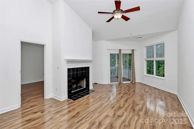 an empty room with windows and fireplace
