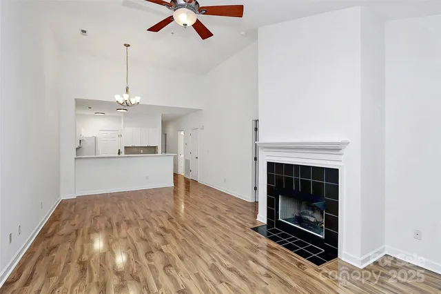 a view of kitchen and empty room with wooden floor