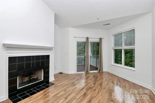 a view of an empty room with window and fire place