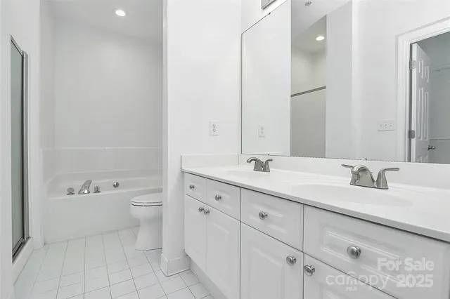 a bathroom with a granite countertop sink mirror and toilet
