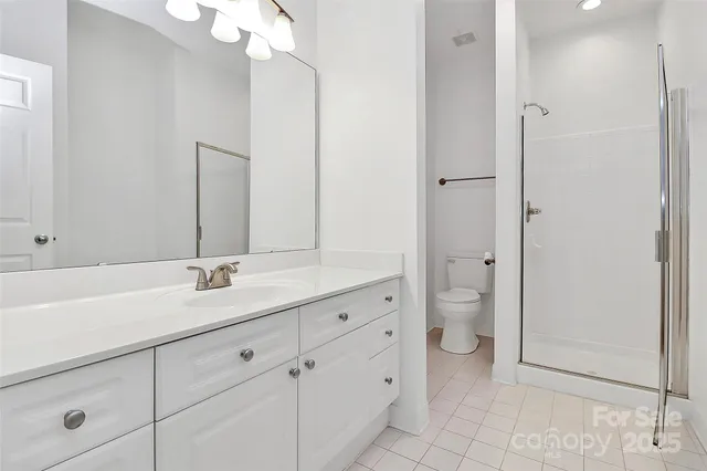 a bathroom with a granite countertop sink a toilet and a mirror