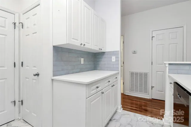 a kitchen with white cabinets and white appliances