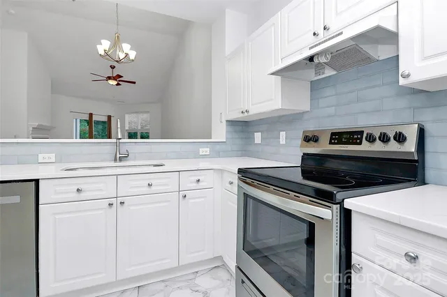 a kitchen with white cabinets and appliances