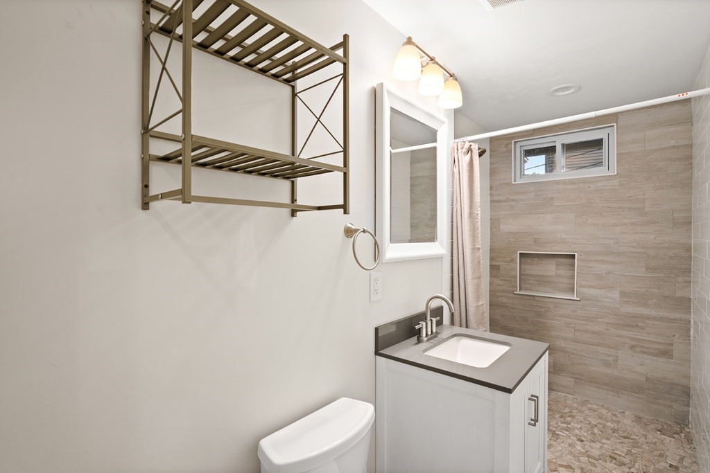 226 East Cottage Street, Unit 1 Boston, MA 02125 - Photo 11 of 12 a bathroom with a toilet sink and mirror