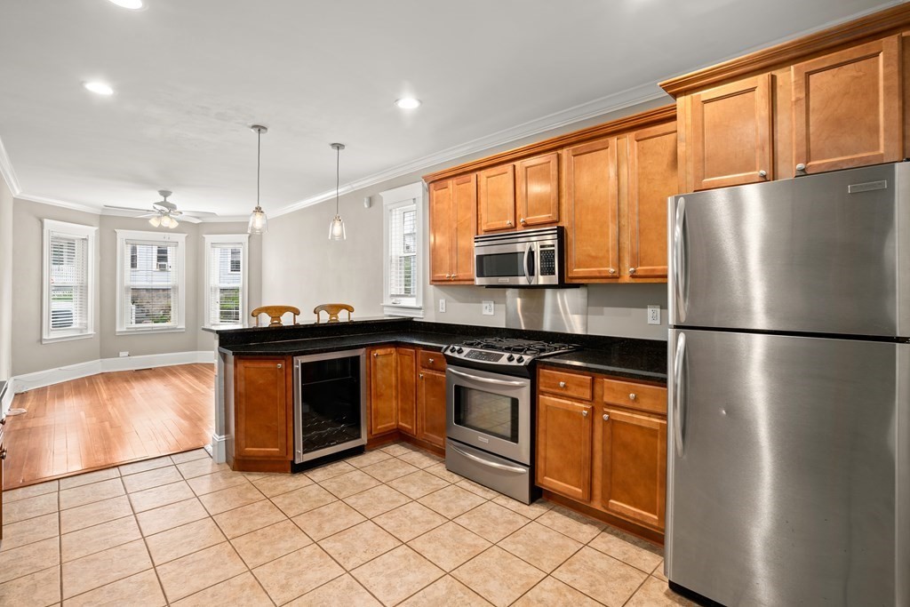 226 East Cottage Street, Unit 1 Boston, MA 02125 - Photo 3 of 12 a kitchen with stainless steel appliances granite countertop a refrigerator a stove a sink and a microwave
