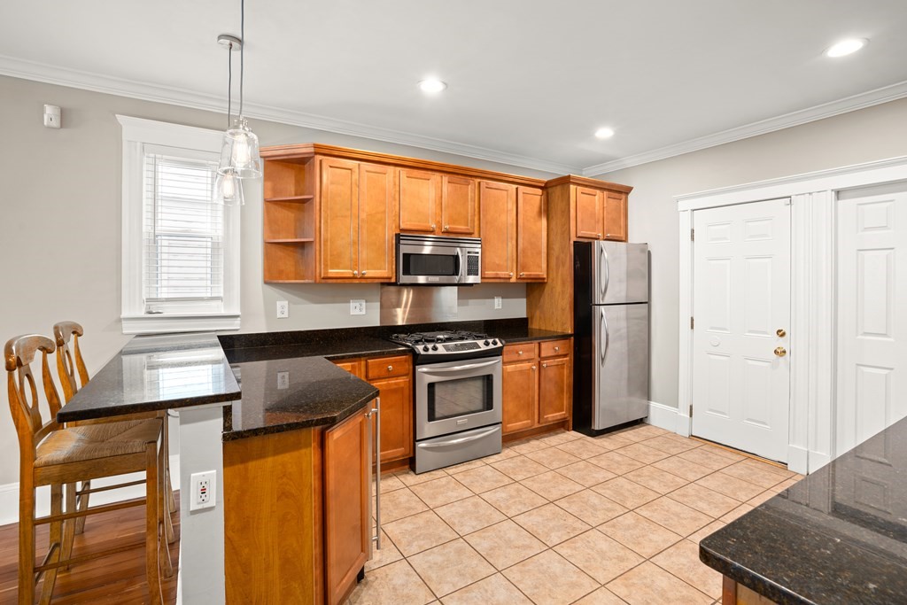 226 East Cottage Street, Unit 1 Boston, MA 02125 - Photo 4 of 12 a kitchen with stainless steel appliances granite countertop a refrigerator and a sink