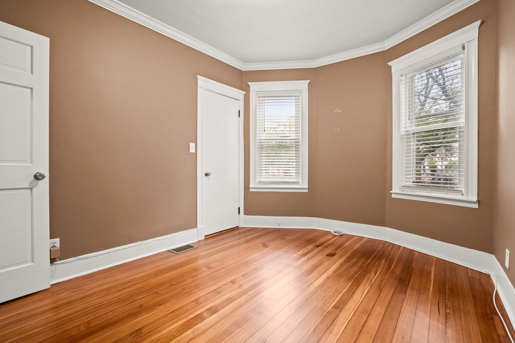 226 East Cottage Street, Unit 1 Boston, MA 02125 - Photo 10 of 12 an empty room with wooden floor and windows