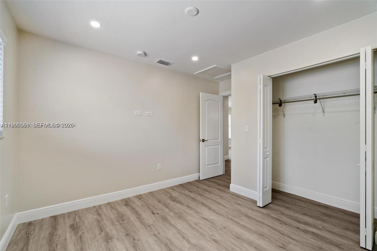 330 West 74th Place, Unit 330 Hialeah, FL 33014 - Photo 16 of 31 a view of an empty room with wooden floor and a bathroom