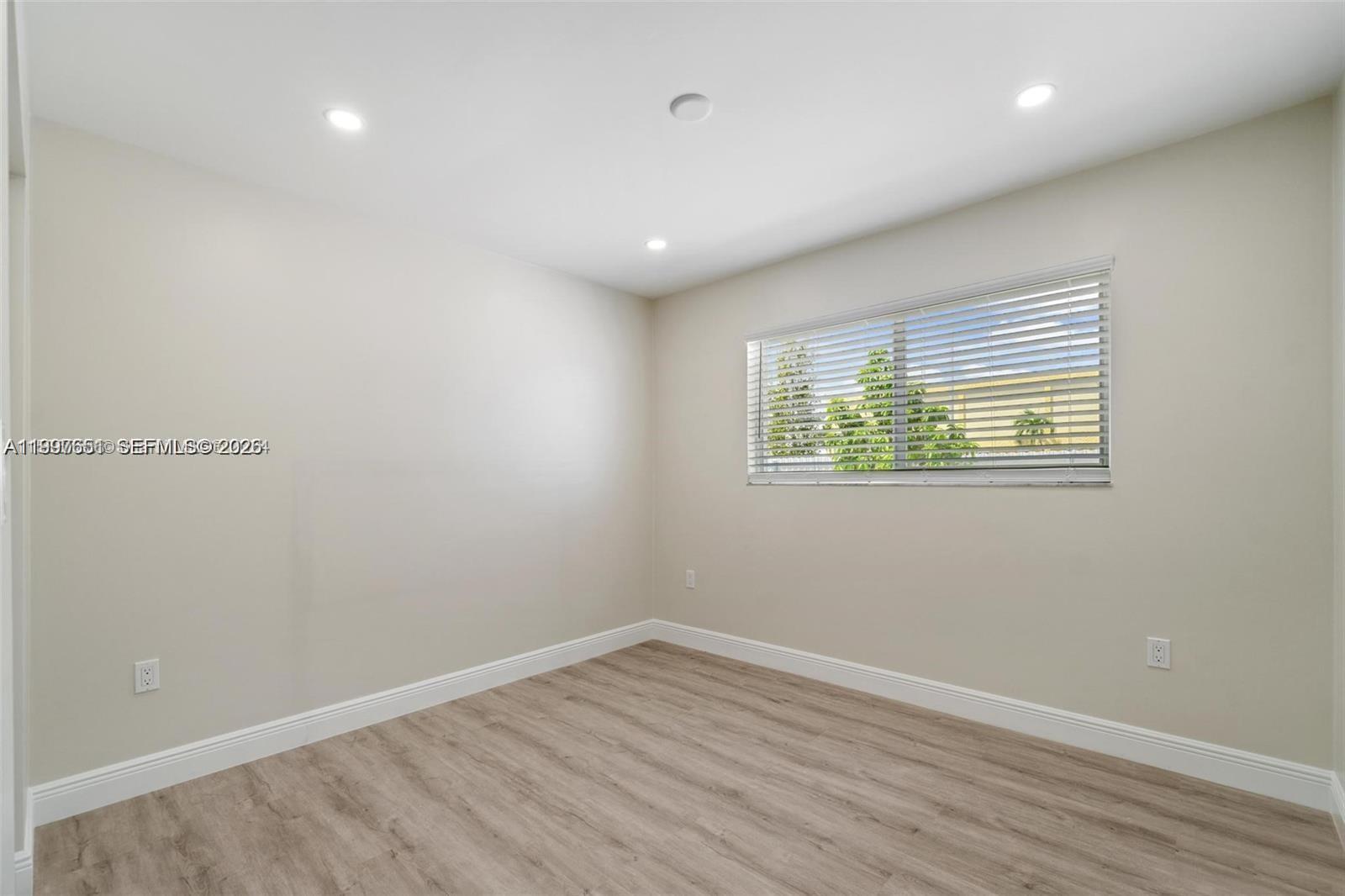 330 West 74th Place, Unit 330 Hialeah, FL 33014 - Photo 17 of 31 wooden floor in an empty room with a window