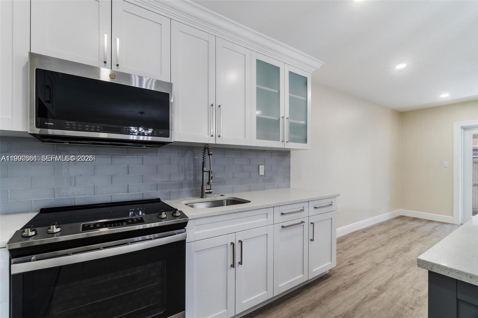330 West 74th Place, Unit 330 Hialeah, FL 33014 - Photo 23 of 31 a kitchen with stainless steel appliances a stove a microwave and cabinets