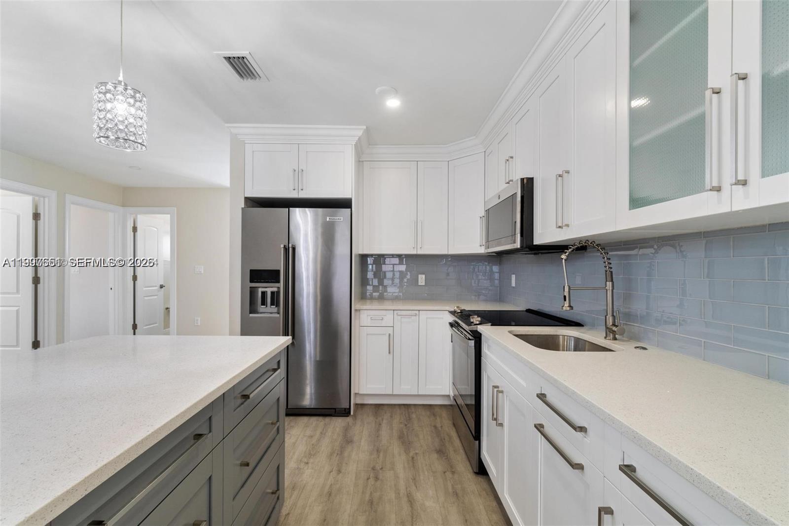 330 West 74th Place, Unit 330 Hialeah, FL 33014 - Photo 25 of 31 a kitchen with white cabinets and stainless steel appliances