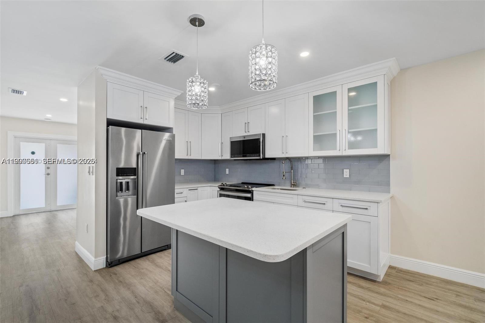 330 West 74th Place, Unit 330 Hialeah, FL 33014 - Photo 26 of 31 a kitchen with a center island wooden floor and stainless steel appliances