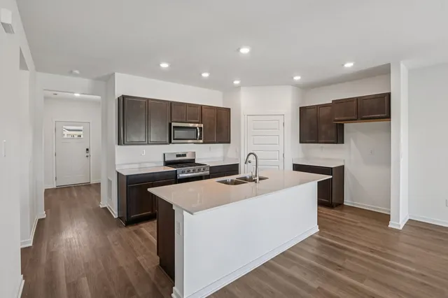 a kitchen that has a sink a stove and chairs