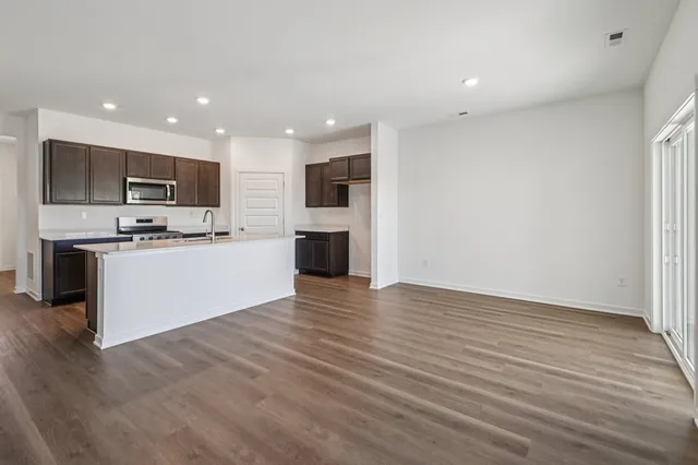 a kitchen with kitchen island a sink stainless steel appliances and cabinets