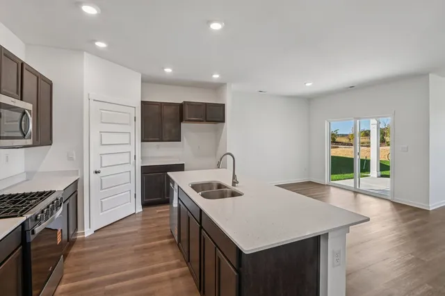 a kitchen with kitchen island a sink appliances and cabinets