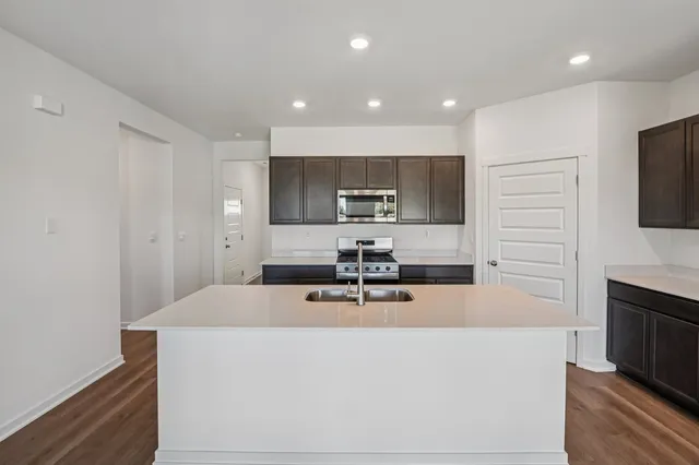 a kitchen with sink a microwave and cabinets