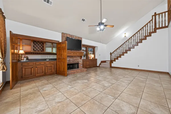 a view of a livingroom with furniture a flat screen tv and kitchen view