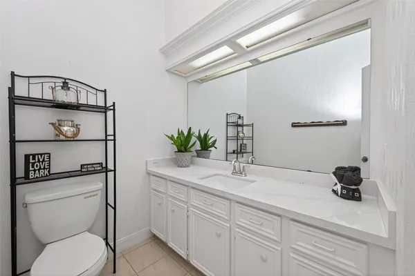 a kitchen with white cabinets and sink
