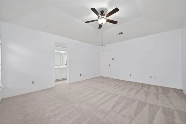 an empty room with windows and ceiling fan