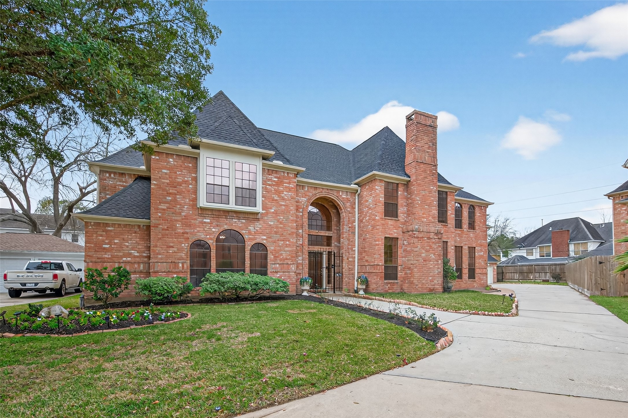 17315 Rothko Lane Spring, TX 77379 - Photo 3 of 50 This spacious residence features a grand arched entry, soaring windows that provide natural light and a striking central chimney. The classic brick exterior is complemented by mature landscaping, and a well-maintained lawn.