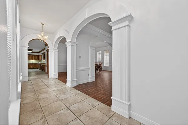 an empty room with wooden floor fireplace and windows