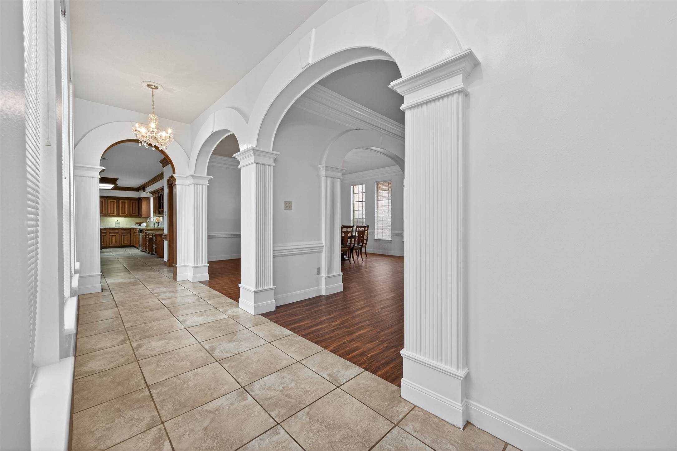 17315 Rothko Lane Spring, TX 77379 - Photo 8 of 50 This hallway showcases elegant architectural details including decorative columns, crown molding, beautiful finishes, natural light. The tile flooring flows seamlessly into rich wood floors, creating a warm and invitating space.