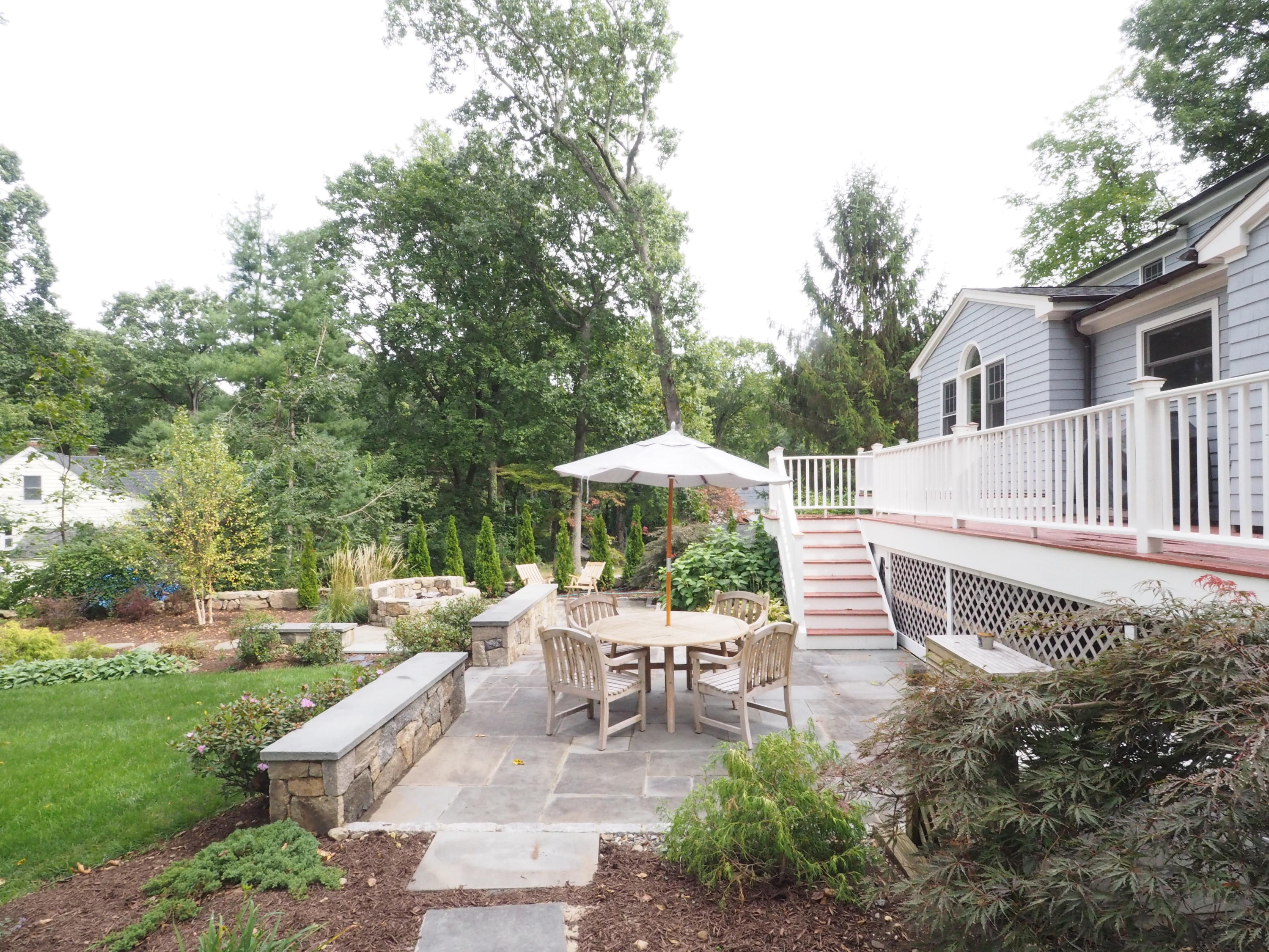 25 Ridgewood Road Norwalk, CT 06853 - Photo 28 of 37 a view of a patio with a table and chairs under an umbrella with large trees