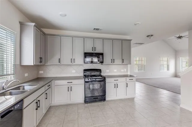 a large kitchen with a stove top oven sink and cabinets