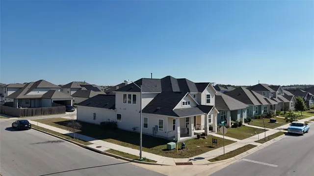 a front view of residential houses with cars parked