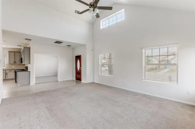 en empty room with windows and ceiling fan