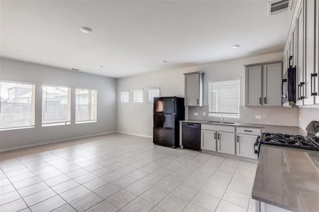 a kitchen with granite countertop a refrigerator stove top oven and sink
