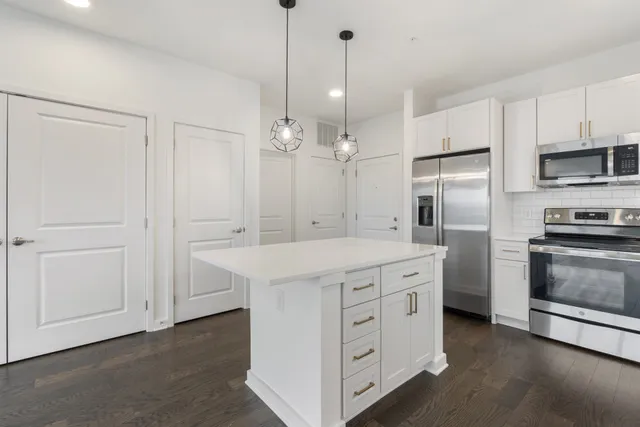 a living room with furniture large windows and wooden floor