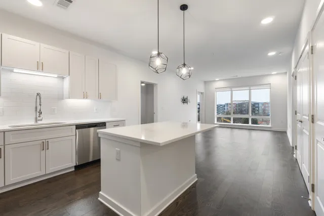 a living room with furniture wooden floor and a large window
