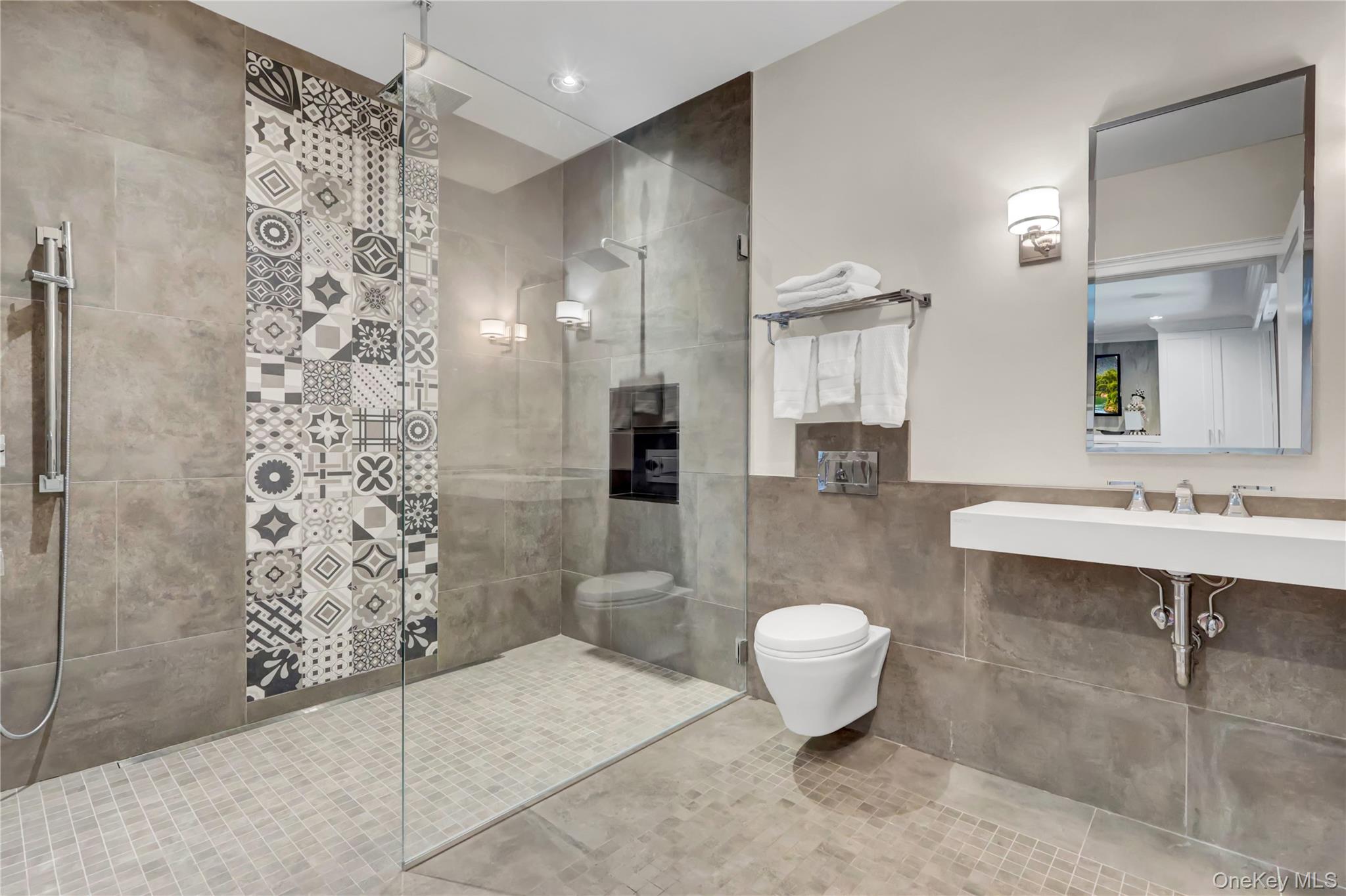 63 Dyke Road Setauket, NY 11733 - Photo 16 of 49 Bathroom featuring walk in shower, tile walls, tile patterned floors, and a wainscoted wall