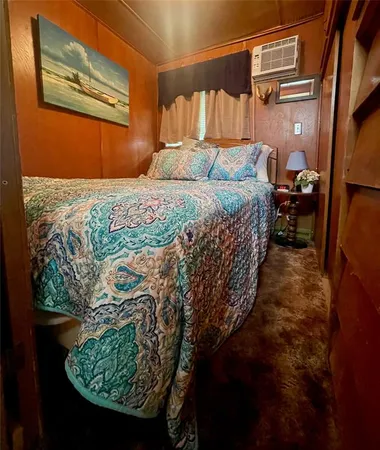 a bedroom with a bed a dresser and a painting