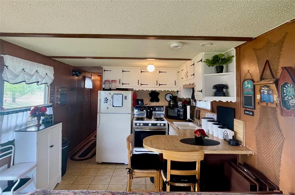 641 Sky Camp Loop, Unit 2 Graford, TX 76449 - Photo 8 of 29 a kitchen with stainless steel appliances kitchen island granite countertop a refrigerator and microwave