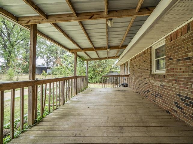 660 Hinton Road Counce, TN 38326 - Photo 29 of 40 Expansive wood-finish deck with a metal roof and wood railing