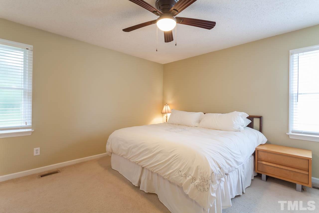 2013 Broadingham Court Raleigh, NC 27615 - Photo 13 of 21 a bedroom with a bed and a chandelier