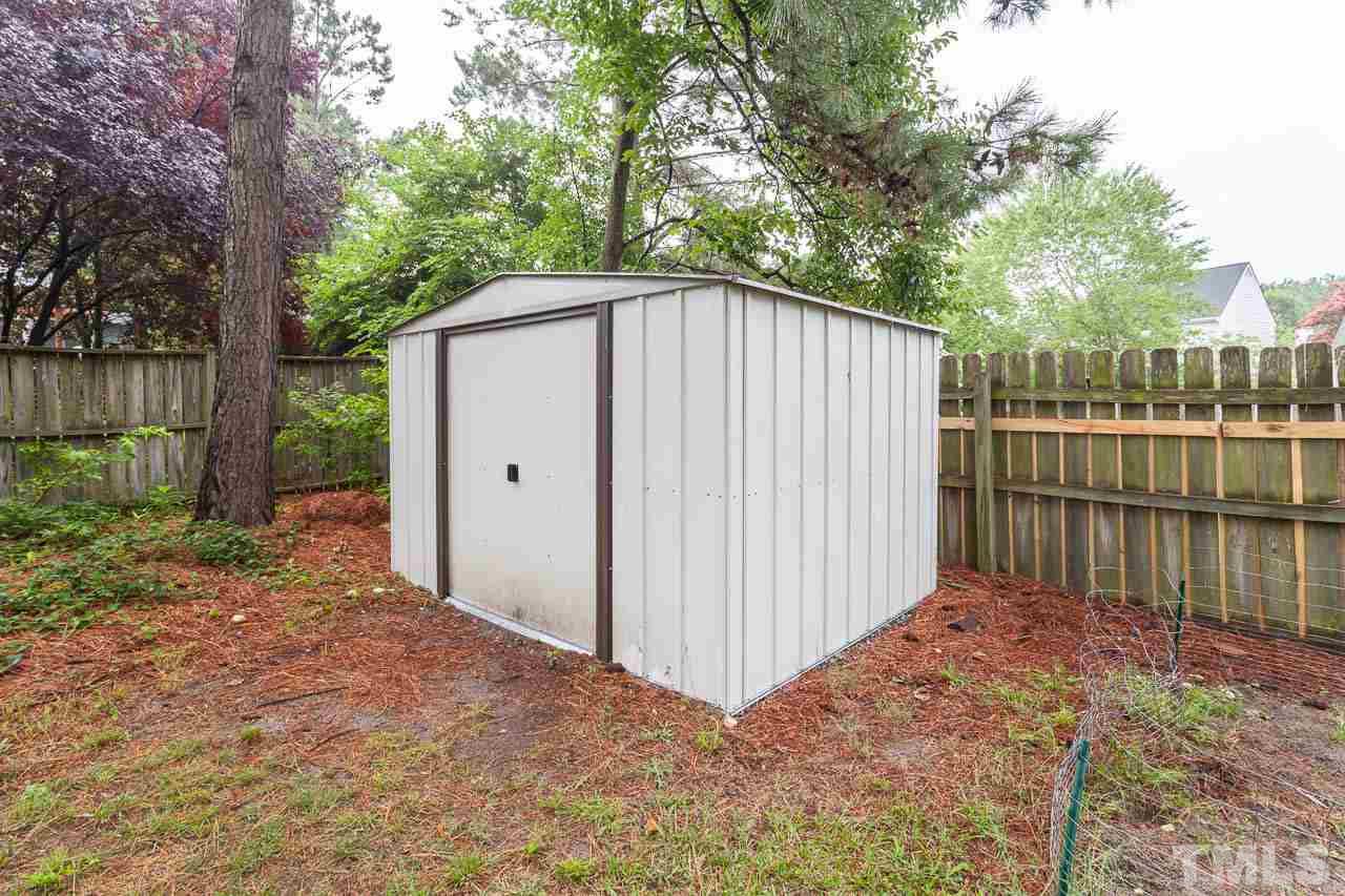 2013 Broadingham Court Raleigh, NC 27615 - Photo 21 of 21 a view of a backyard with a small cabin and a chair