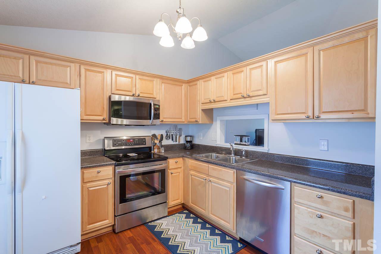2013 Broadingham Court Raleigh, NC 27615 - Photo 5 of 21 a kitchen with stainless steel appliances granite countertop a stove a sink dishwasher and a refrigerator with wooden cabinets