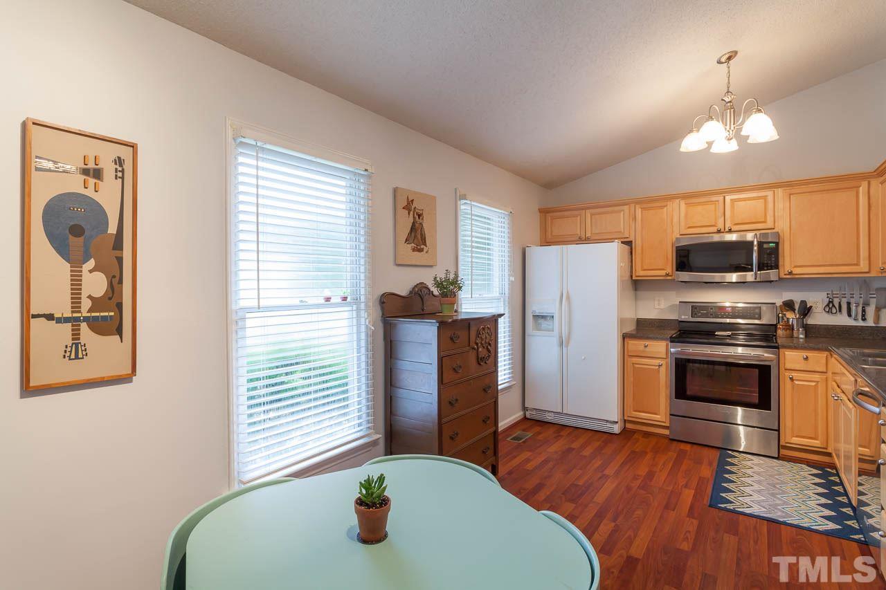 2013 Broadingham Court Raleigh, NC 27615 - Photo 6 of 21 a kitchen with stainless steel appliances granite countertop a refrigerator a oven a sink a dining table and chairs with wooden floor