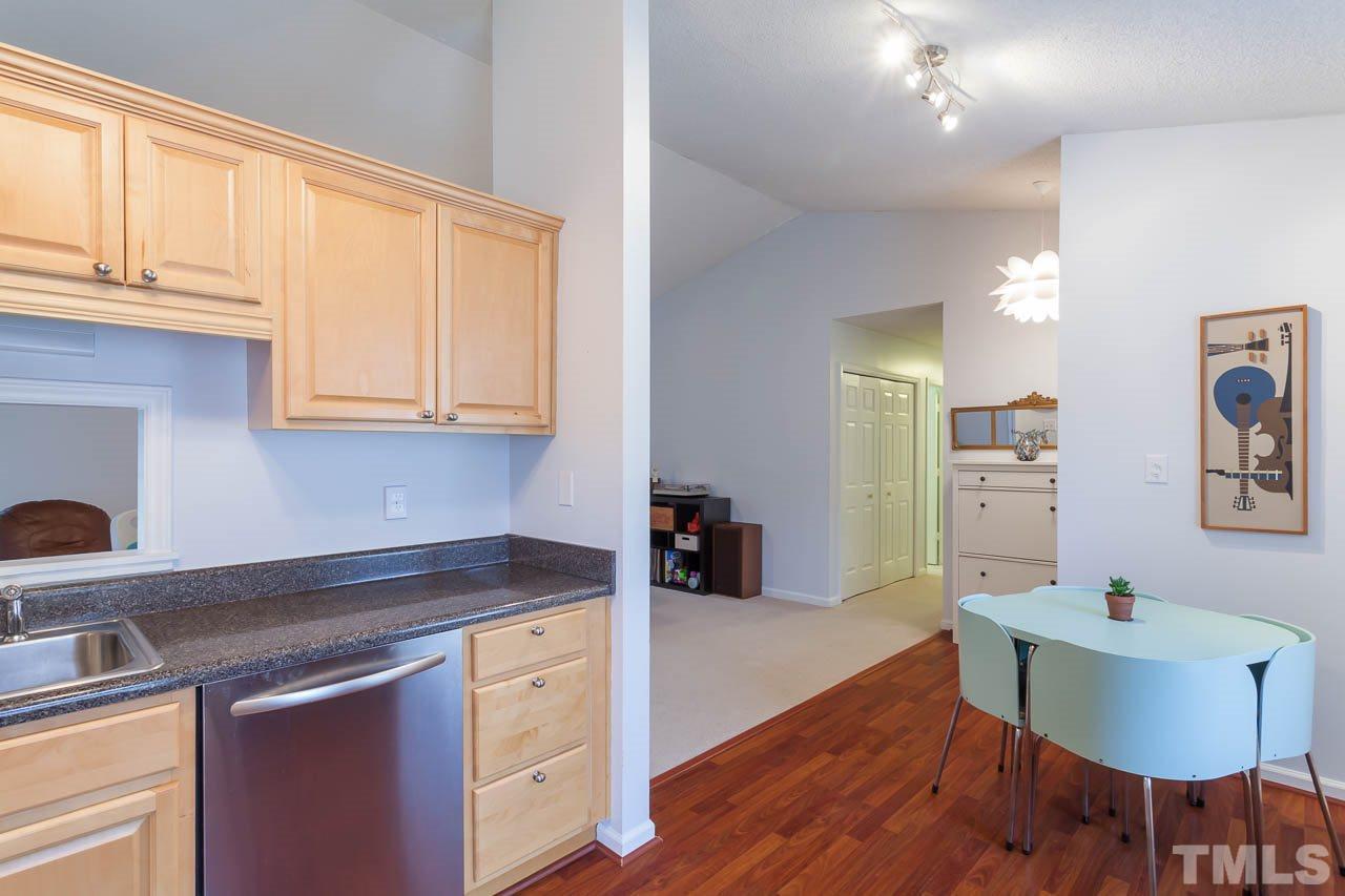 2013 Broadingham Court Raleigh, NC 27615 - Photo 7 of 21 a kitchen with stainless steel appliances granite countertop a sink a stove a dining table and chairs with wooden floor