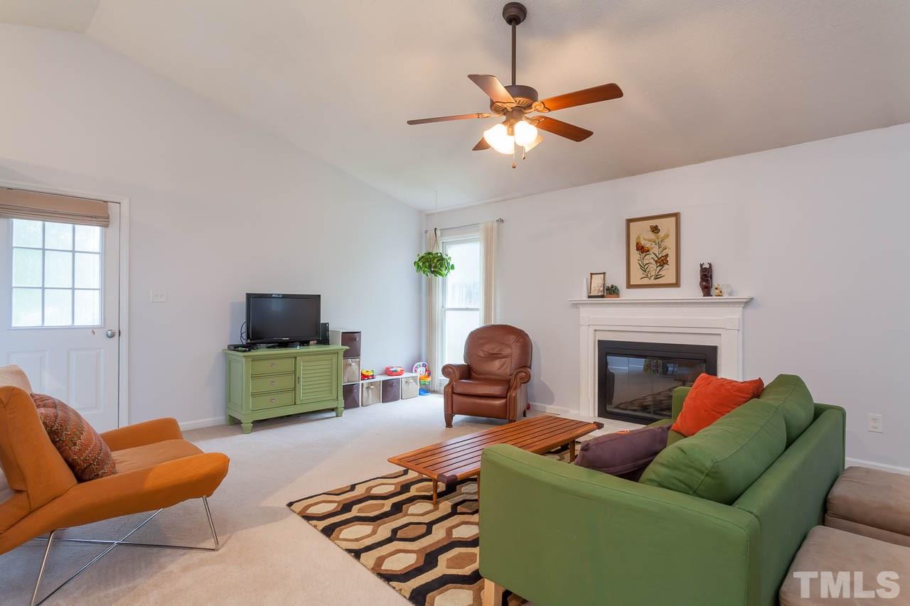 2013 Broadingham Court Raleigh, NC 27615 - Photo 9 of 21 a living room with furniture a chandelier and a fireplace