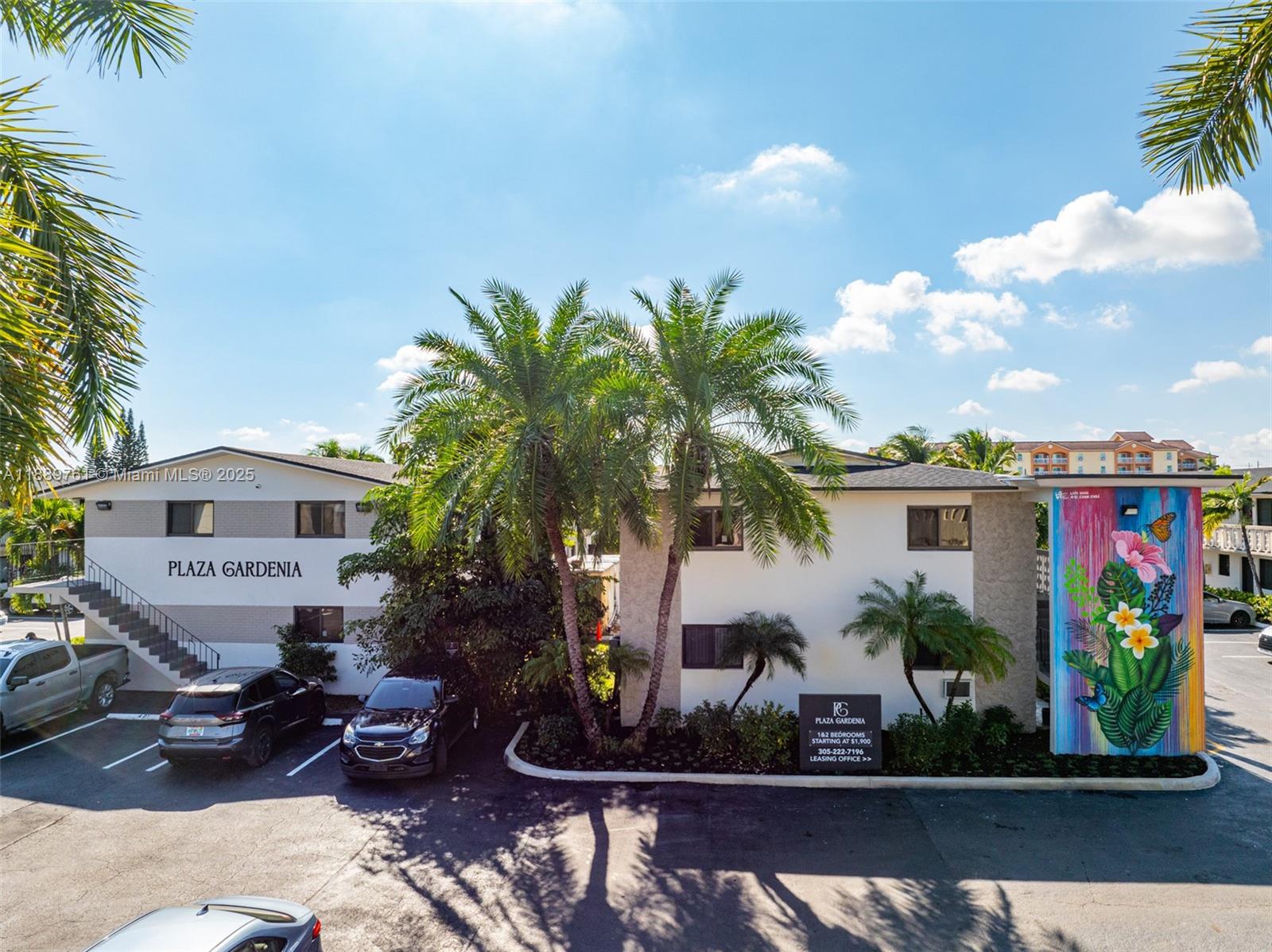 a front view of a house with a yard and potted plants