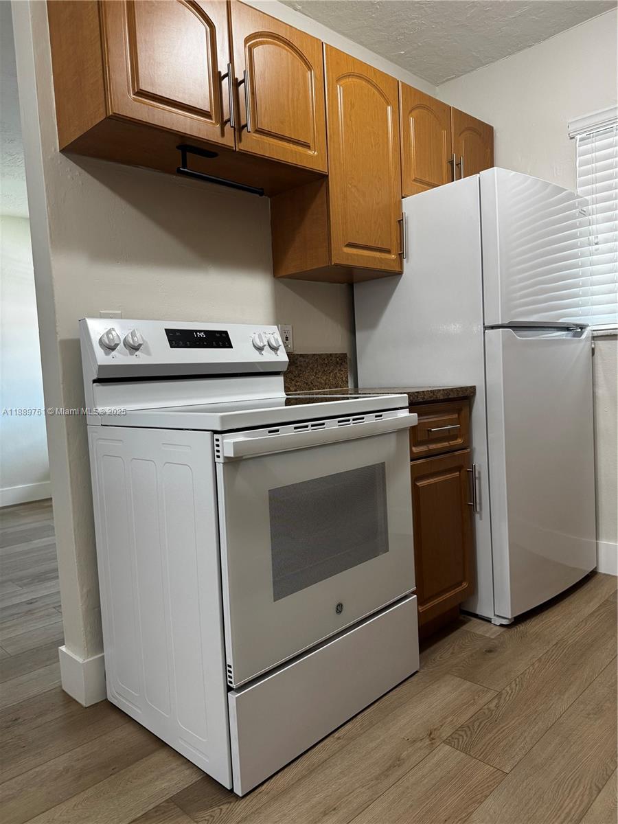 1330 West 29th Street, Unit 30 Hialeah, FL 33012 - Photo 4 of 13 a kitchen with a stove top oven and cabinets