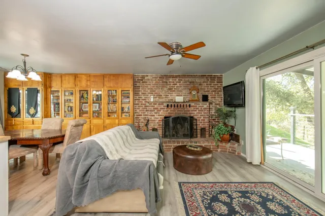 a living room with furniture a fireplace and a floor to ceiling window