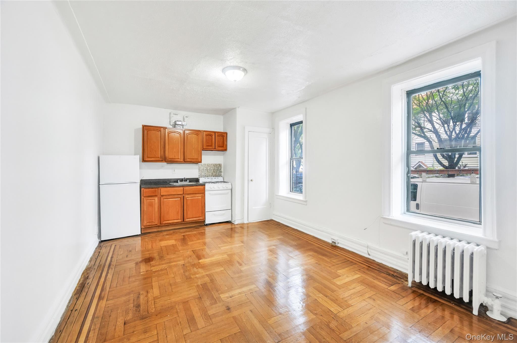 3152 Hull Avenue Bronx, NY 10467 - Photo 14 of 35 a big room with wooden floor windows and a kitchen