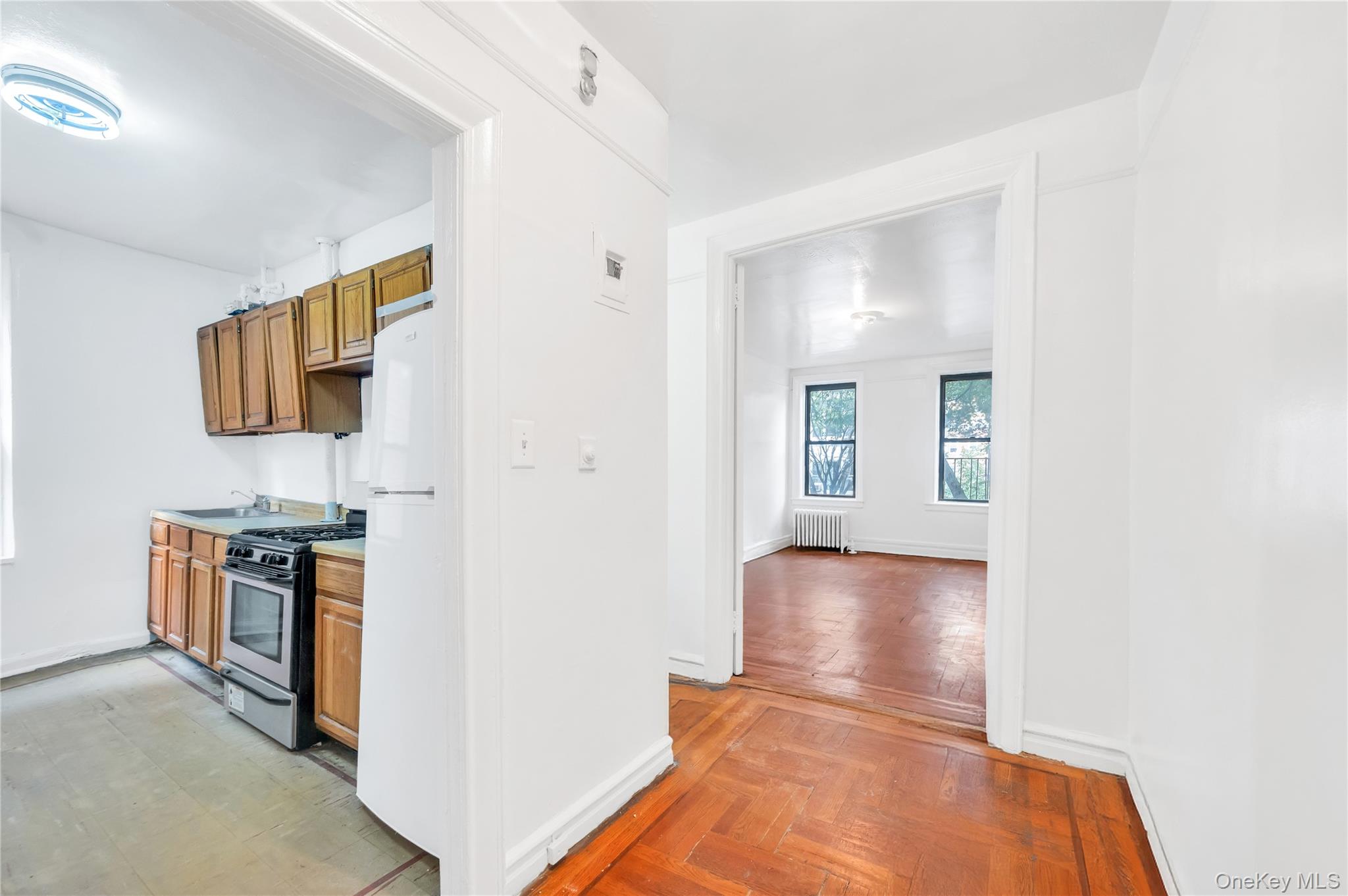 3152 Hull Avenue Bronx, NY 10467 - Photo 8 of 35 a view of kitchen and empty room with wooden floor