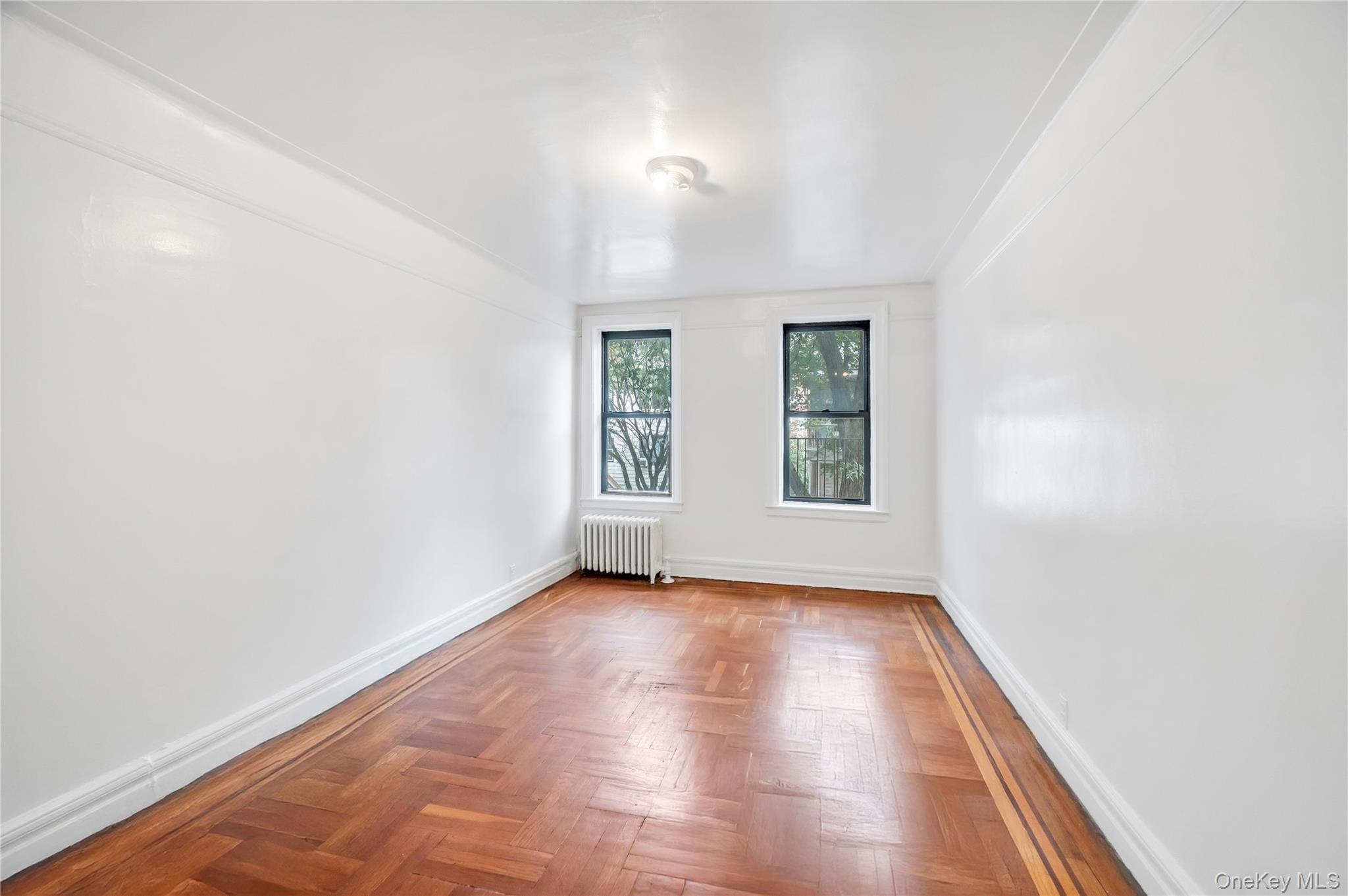 3152 Hull Avenue Bronx, NY 10467 - Photo 9 of 35 an empty room with wooden floor and windows
