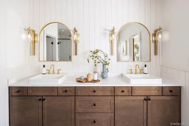 a bathroom with double vanity sinks and a two mirror